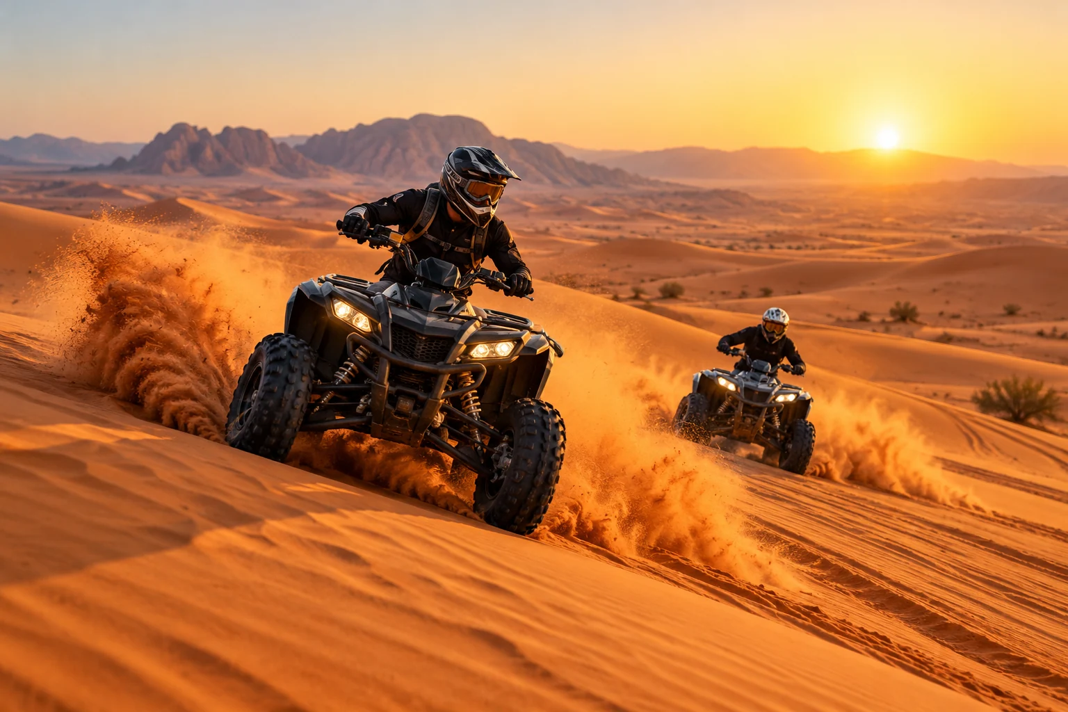 Helmeted riders quad biking over golden desert dunes